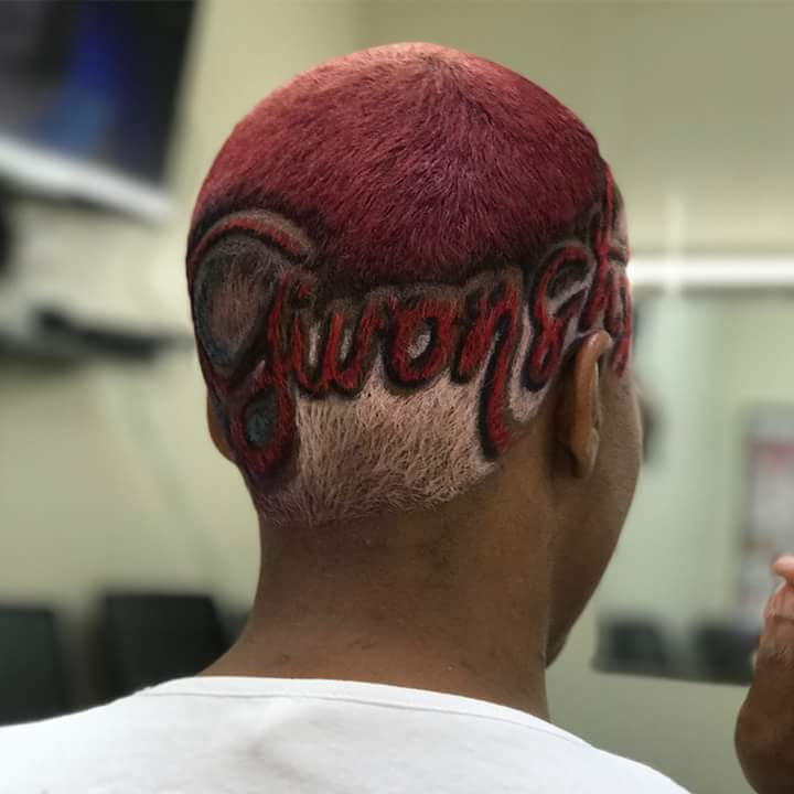 Custom hair design with red dye and carved lettering on back of head