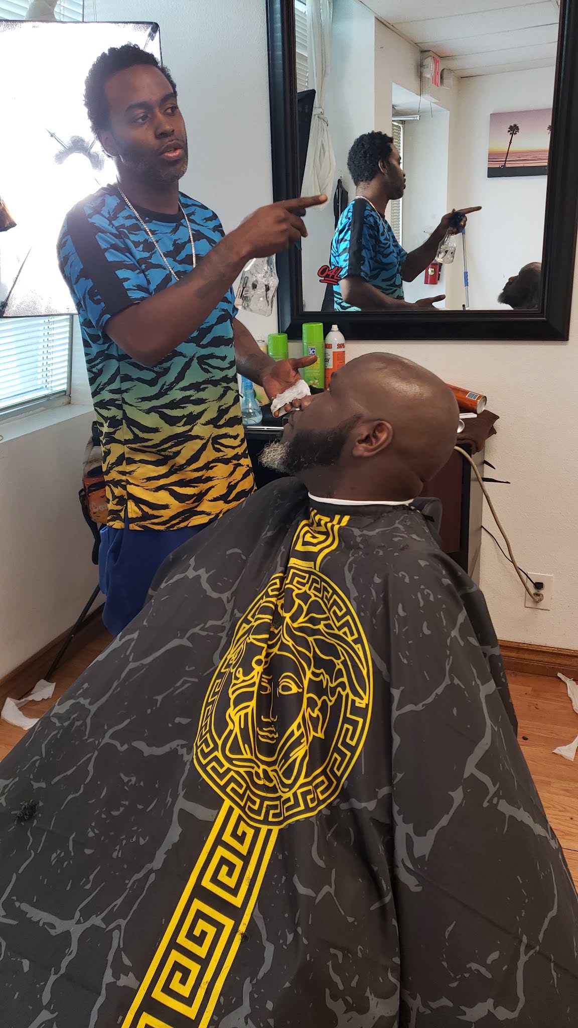 Barber performing a beard shave on a seated client